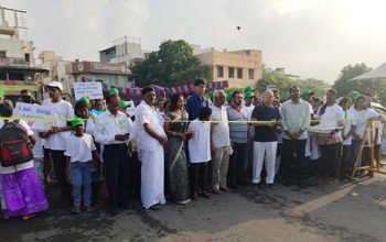 Participants in white caps at the mental health awareness walkathon with United Way Chennai
