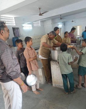 SMART Foundation volunteers serve hot rice meals to children queuing at the Government Children Home for Boys, Ranipet